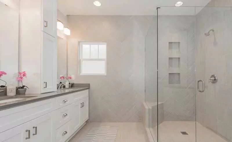 Bathroom with white cabinets and tiling