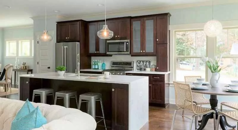 Modern kitchen with brown cabinets and white waterfall countertop